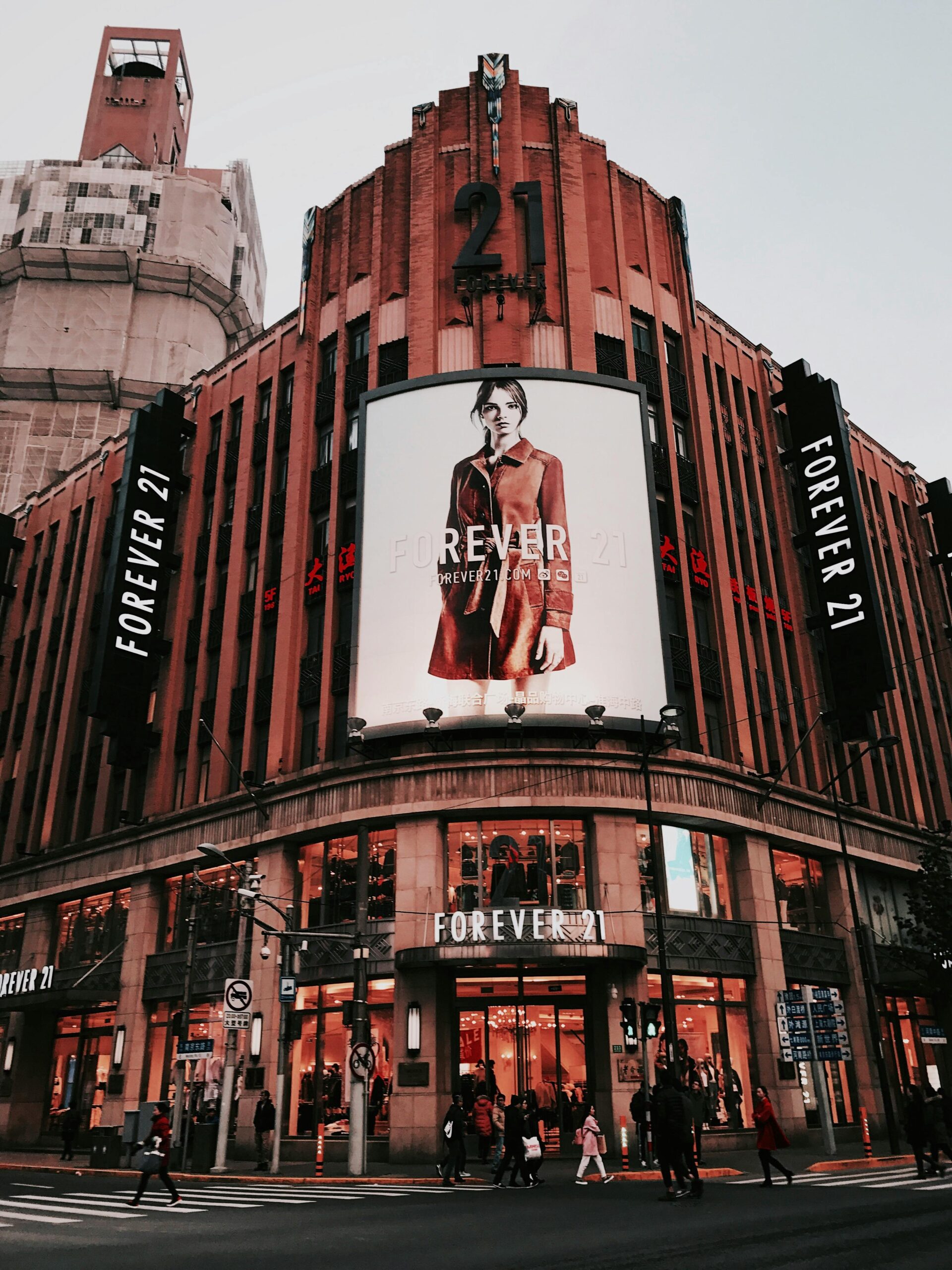 Art Deco building in Shanghai with prominent Forever 21 storefront facade at dusk.