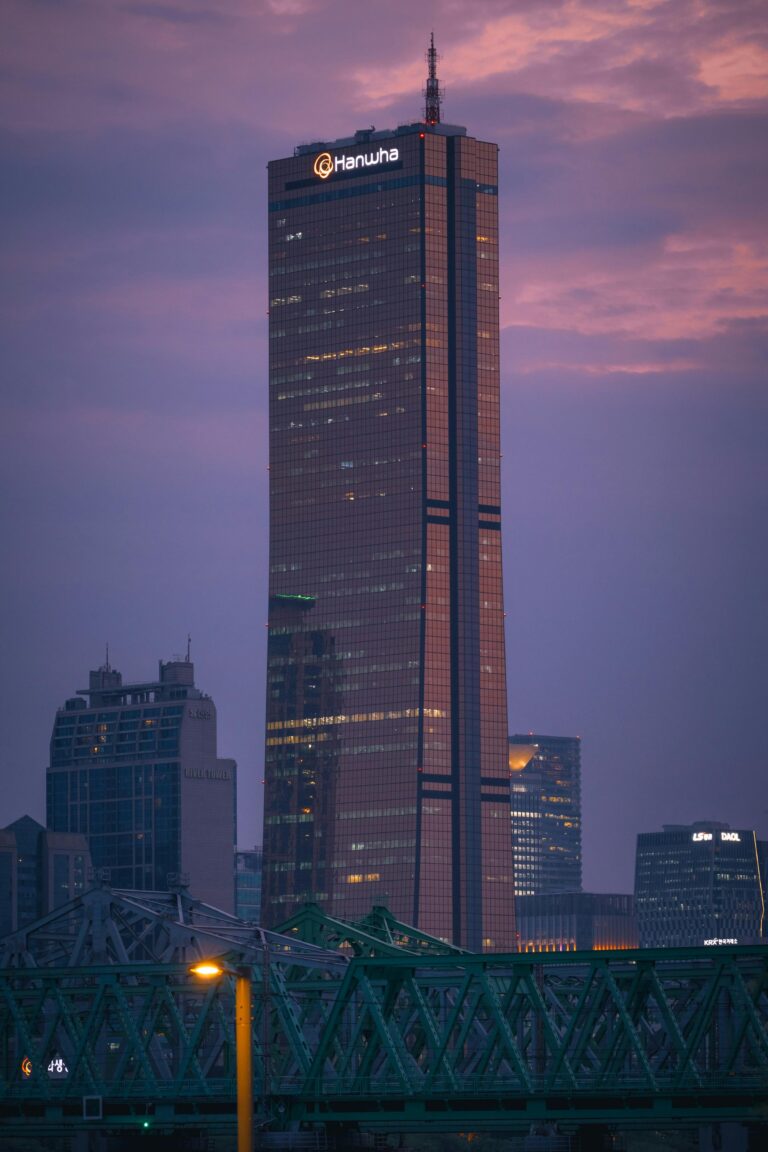 The 63 Building stands tall in Seoul during a dramatic evening sky.